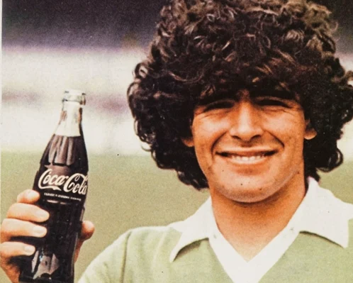 Diego Armando Maradona con una botella de Coca-Cola